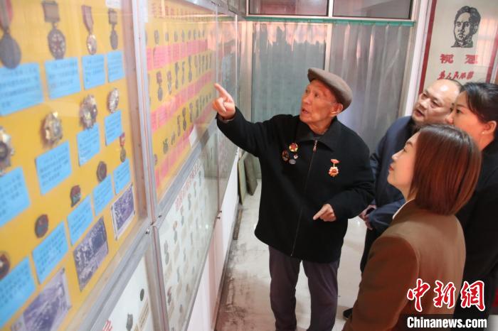图为薛金玉向参观者讲解藏品背后的历史。 齐雄 摄 图为薛金玉向参观者讲解藏品背后的历史。 齐雄 摄
